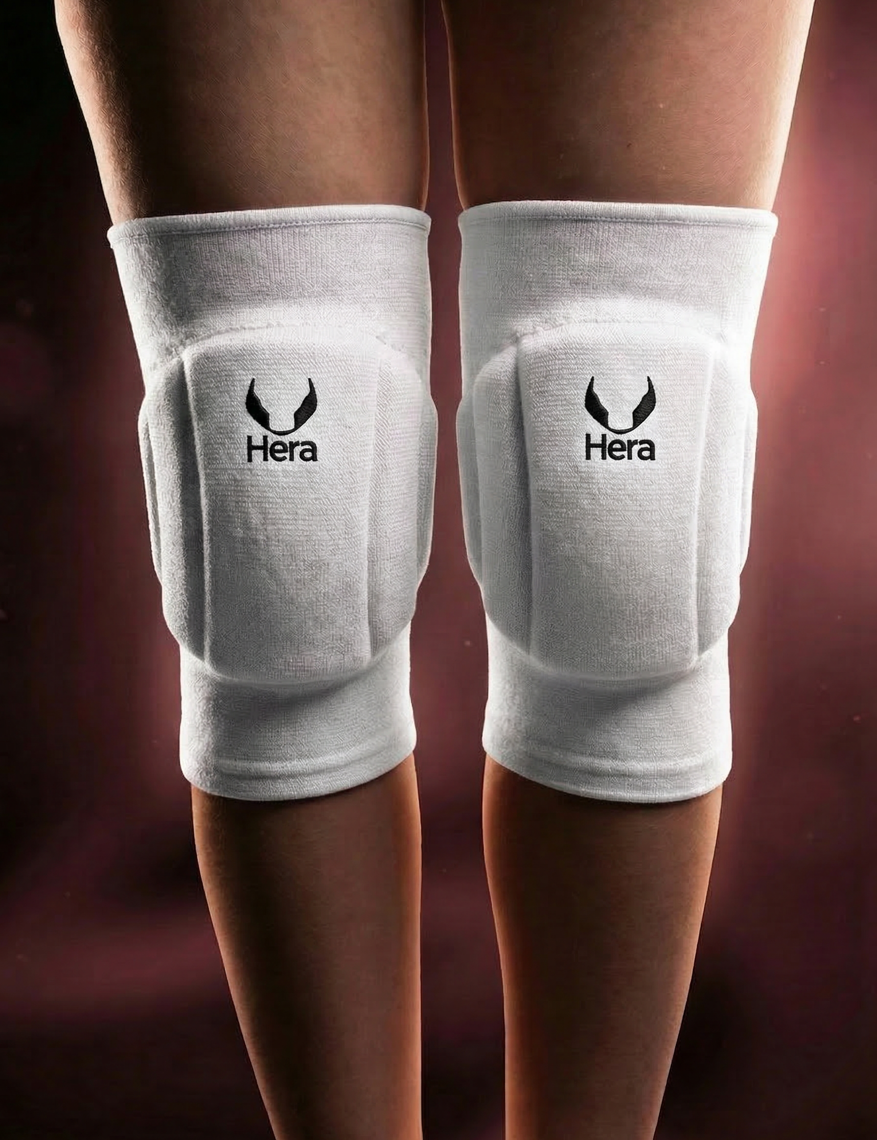 White knee pads with Hera logo on a dark background