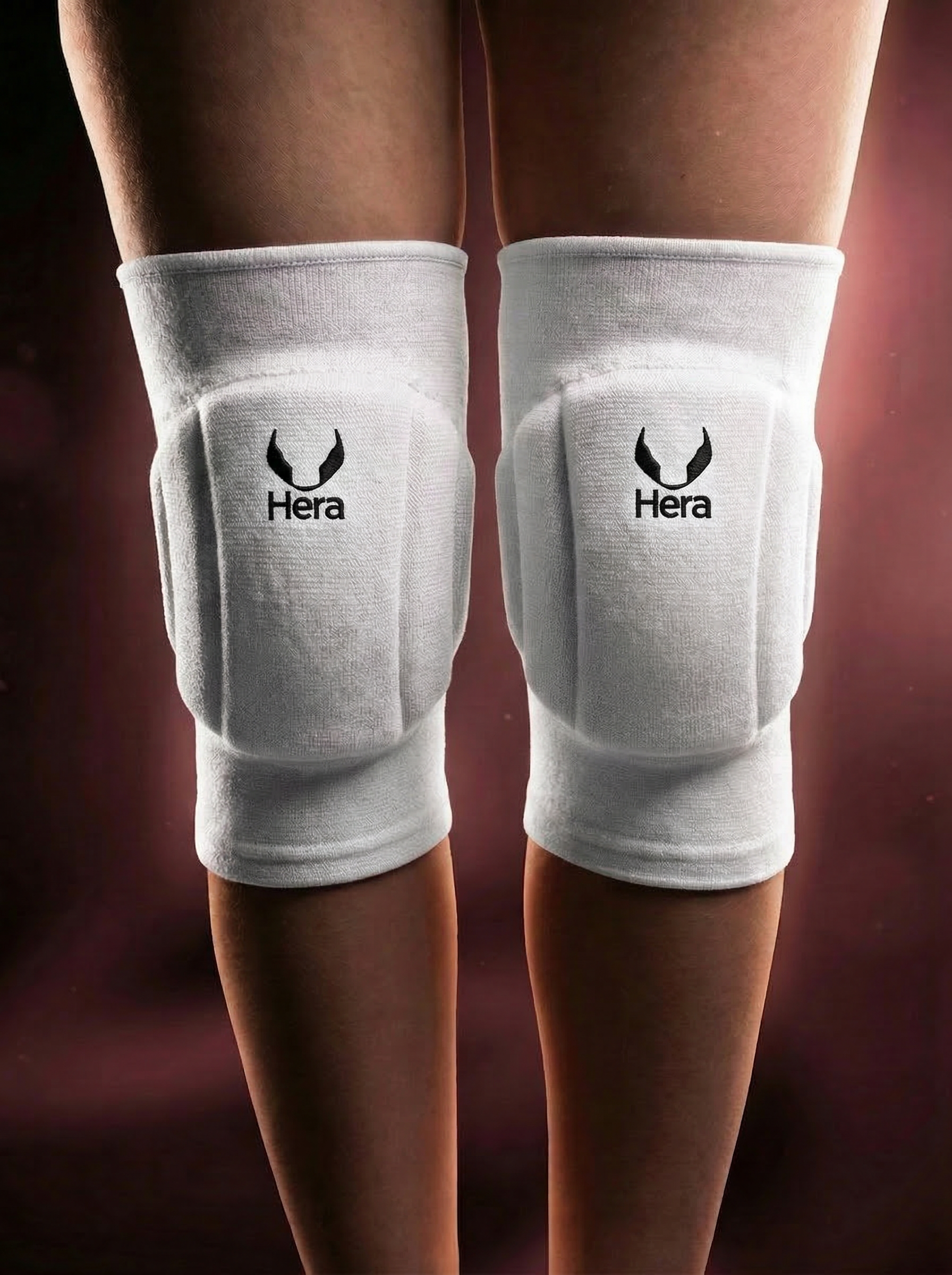 White knee pads with Hera logo on a dark background